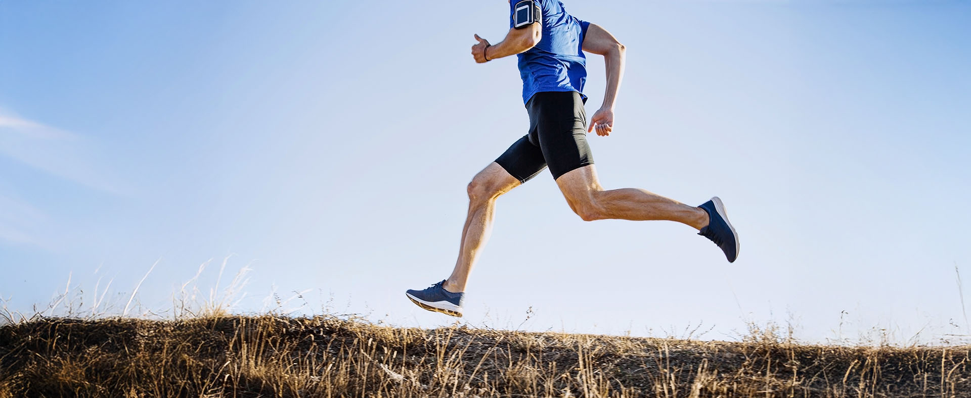Low section woman exercising field against clear sky